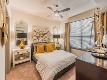 A bedroom with a bed, a dresser, and a mirror.